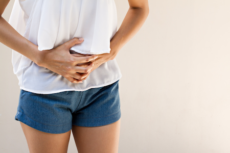 woman holding stomach in pain